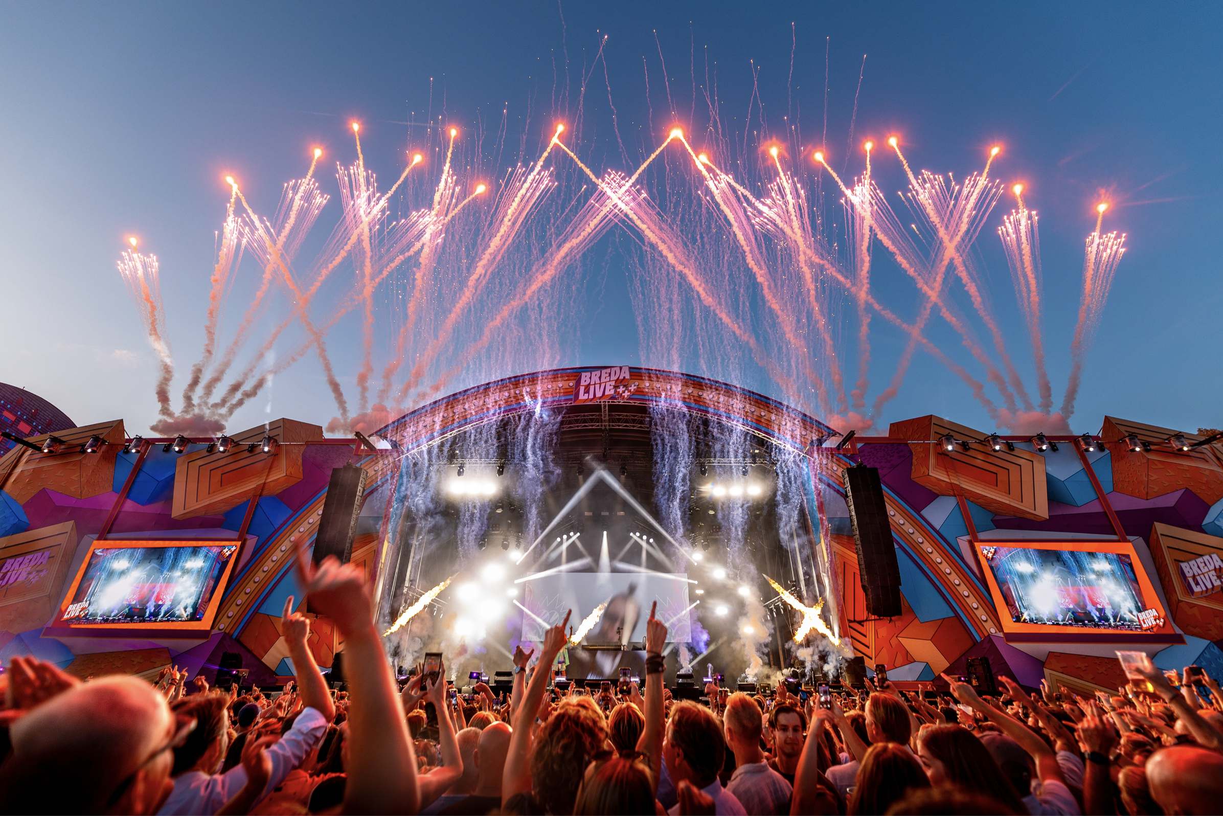 Festivalpodium met vuurwerk en signing op een druk festival